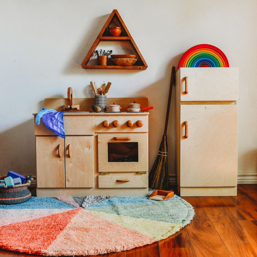 Bella Luna Wooden Kitchen and Refrigerator with door closed in playroom on wooden floor