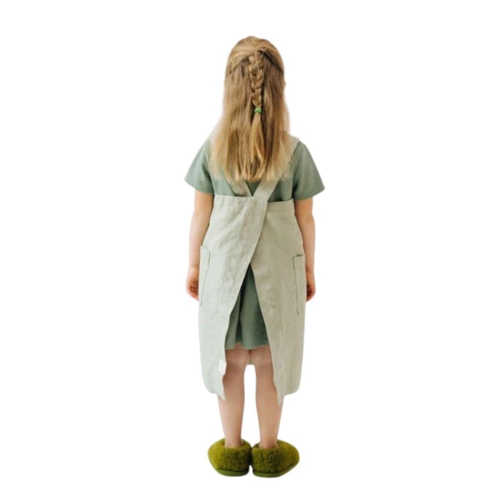 Child wearing Sage Apron, back view